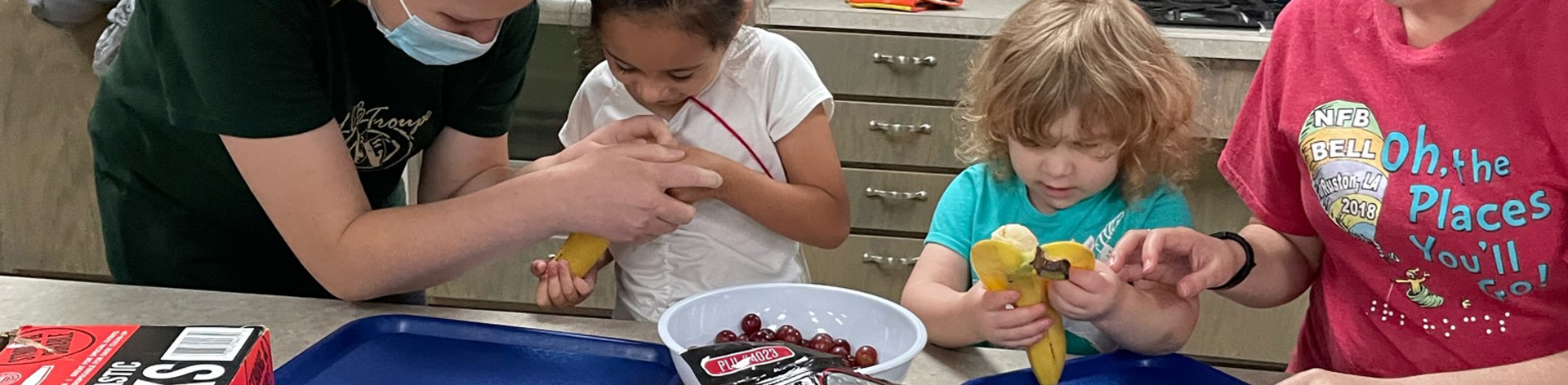 Two NFB BELL students work in the kitchen with mentors.
